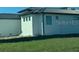 Side view of a modern, single-story home with a metal roof at 24092 Potosi Ct, Punta Gorda, FL 33955