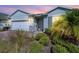 Charming home with light blue exterior, two-car garage, and well-manicured landscaping at 43015 Parkside Ct, Punta Gorda, FL 33982