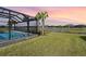 Screened pool with lake view and lush landscaping at 43015 Parkside Ct, Punta Gorda, FL 33982