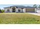 Single-story house with a two-car garage and a large grassy yard at 12333 Willmington Blvd, Port Charlotte, FL 33981