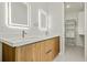 Double vanity bathroom with illuminated mirrors and linen closet at 14431 Artesia Ave, Port Charlotte, FL 33981