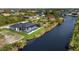 Aerial view of canal-front home with pool and screened enclosure at 14431 Artesia Ave, Port Charlotte, FL 33981