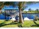 Covered boat dock with boat lift, prep station, and two Adirondack chairs at 161 Carlisle Nw Ave, Port Charlotte, FL 33952