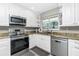 Updated kitchen with stainless appliances, white cabinets, and natural lighting at 161 Carlisle Nw Ave, Port Charlotte, FL 33952