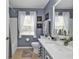 Well-lit bathroom with gray walls, white vanity, and bathtub shower combo at 17396 Cox Ave, Port Charlotte, FL 33948