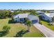 Single-story home with metal roof, driveway, and tropical landscaping at 17458 Fuego Ln, Punta Gorda, FL 33955