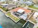 An aerial view of the rear of a waterfront home with a boat lift, screened-in pool, boat dock, and canal access at 1923 Pennsylvania Ave, Englewood, FL 34224