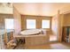 Bathroom with a tile-surround jacuzzi tub and separate walk-in shower, all illuminated by natural light from nearby windows at 1923 Pennsylvania Ave, Englewood, FL 34224