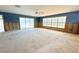 Spacious living room featuring sliding glass doors and large windows for natural light with a ceiling fan overhead at 1923 Pennsylvania Ave, Englewood, FL 34224