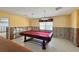Recreational room with a red felt pool table and overhead lighting, illuminated by a window at 1923 Pennsylvania Ave, Englewood, FL 34224