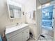 Clean bathroom featuring a white vanity, a large mirror, and an open doorway into the primary bedroom at 207 Blackburn Blvd, North Port, FL 34287