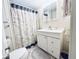 Nautical-themed bathroom featuring a sink vanity with storage, neutral walls, and a unique, decorative shower curtain at 207 Blackburn Blvd, North Port, FL 34287
