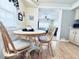 Dining area with a round white table, wood chairs, and view into the living room at 207 Blackburn Blvd, North Port, FL 34287