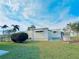 Charming home exterior featuring a well-manicured lawn and lush, mature landscaping at 207 Blackburn Blvd, North Port, FL 34287