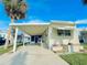 Charming single-story home featuring a covered carport, awning-shaded window, and a well-maintained lawn at 207 Blackburn Blvd, North Port, FL 34287