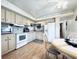 Traditional-style kitchen with white appliances, neutral countertops, and wood-look floors at 207 Blackburn Blvd, North Port, FL 34287