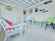 Spacious patio seating area with green chairs and a white wicker sofa, perfect for relaxing at 207 Blackburn Blvd, North Port, FL 34287