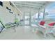 Enclosed screened-in porch for outdoor enjoyment with seating and a view of the neighborhood at 207 Blackburn Blvd, North Port, FL 34287