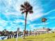 A waterfront view with docks, a grassy area, and palm trees under a beautiful blue sky at 207 Blackburn Blvd, North Port, FL 34287