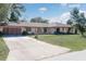 Well-maintained single-story home featuring a large driveway, an attached two-car garage, and a neatly kept front yard at 21533 Dawson Ave, Port Charlotte, FL 33952