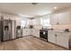 Modern kitchen with white cabinets, stainless steel appliances, and light wood flooring at 1010 Robinhood Dr, Punta Gorda, FL 33982