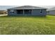 A well-maintained backyard features a spacious lawn and modern exterior at 14154 Baracoa Ln, Port Charlotte, FL 33981