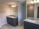Bathroom featuring double sinks with granite countertops, a tile shower, and gray cabinetry at 14154 Baracoa Ln, Port Charlotte, FL 33981