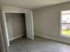 A neutral bedroom with tile flooring, baseboard trim, a window, and a closet at 14154 Baracoa Ln, Port Charlotte, FL 33981