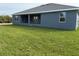 Modern home features a large yard, neutral gray exterior, and covered porch area at 14154 Baracoa Ln, Port Charlotte, FL 33981