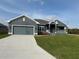 Charming single-story home with well-maintained lawn, covered porch, and gray color palette at 14154 Baracoa Ln, Port Charlotte, FL 33981