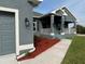Home exterior displaying a covered front porch with white railings and new landscaping at 14154 Baracoa Ln, Port Charlotte, FL 33981