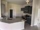 Modern kitchen featuring granite countertops, stainless steel appliances, and gray wood-look tile flooring at 14154 Baracoa Ln, Port Charlotte, FL 33981