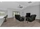 Spacious living room with vaulted ceiling, ceiling fan, and black leather furniture at 17494 Iago Ave, Port Charlotte, FL 33954