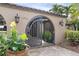 Ornate iron gate and landscaping at home entrance at 1925 Jamaica Way, Punta Gorda, FL 33950