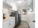 Bright laundry room with white cabinets, granite countertops, and modern appliances at 1925 Jamaica Way, Punta Gorda, FL 33950