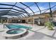 Spacious pool area with a hot tub, screened enclosure, and canal views at 1925 Jamaica Way, Punta Gorda, FL 33950