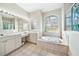 Elegant bathroom with double vanity, large soaking tub, and separate shower at 24282 Silver Ln, Punta Gorda, FL 33955