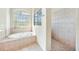 Spa-like bathroom with soaking tub, shower, and decorative tile at 24282 Silver Ln, Punta Gorda, FL 33955