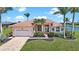 Inviting single-story home with a red tile roof, well-manicured lawn, and lush tropical landscaping at 24282 Silver Ln, Punta Gorda, FL 33955