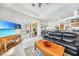 Bright living room with pool view, leather couches, and large TV at 24282 Silver Ln, Punta Gorda, FL 33955