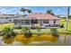 Beautiful rear exterior view showcasing the screened lanai with pool and waterfront views at 24282 Silver Ln, Punta Gorda, FL 33955
