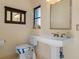 Small bathroom with pedestal sink, toilet and mirror at 2813 Sancho Panza Ct, Punta Gorda, FL 33950