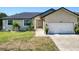 Tan house with a dark roof, white garage door, and landscaping at 3021 Palm Dr, Punta Gorda, FL 33950