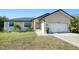 Tan house with a dark roof, white garage door, and landscaping at 3021 Palm Dr, Punta Gorda, FL 33950