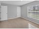 Well-lit bedroom featuring tile floors, a window with blinds, and neutral walls at 12352 Birtle Ave, Port Charlotte, FL 33981