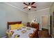 Guest bedroom with wooden frame bed, yellow pillows, and a colorful quilt at 23177 Mcmullen Ave, Port Charlotte, FL 33980