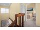 Upstairs hallway with a wooden railing, linen closet, and a glimpse of a bedroom at 25188 Marion Ave # 1006, Punta Gorda, FL 33950