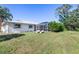 Spacious backyard with grassy area, screened enclosure and lounge chairs at 3014 Guadalupe Dr, Punta Gorda, FL 33950