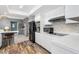 Kitchen with white cabinets, black appliances, and a brick accent wall at 3014 Guadalupe Dr, Punta Gorda, FL 33950