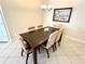 Elegant dining room with dark wood table and six light beige chairs at 10900 Lerwick Cir, Englewood, FL 34223